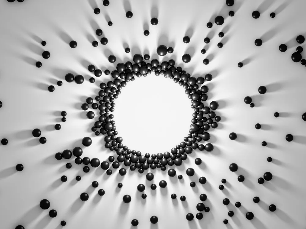 An abstract render: small spheres arranged in a ring radiating outward from a bright centre.